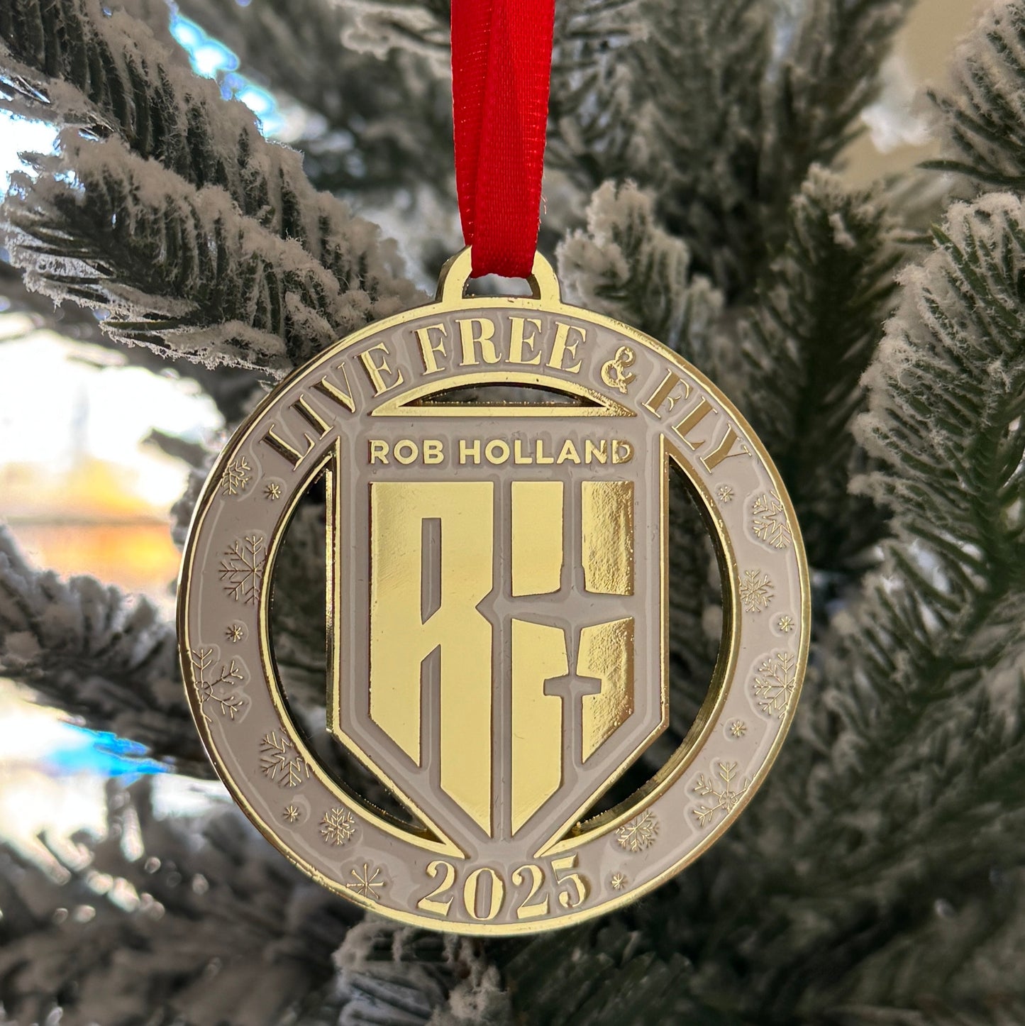Gold ornament with 'Live Free & Fly' text and 'RH' logo on a Christmas tree.