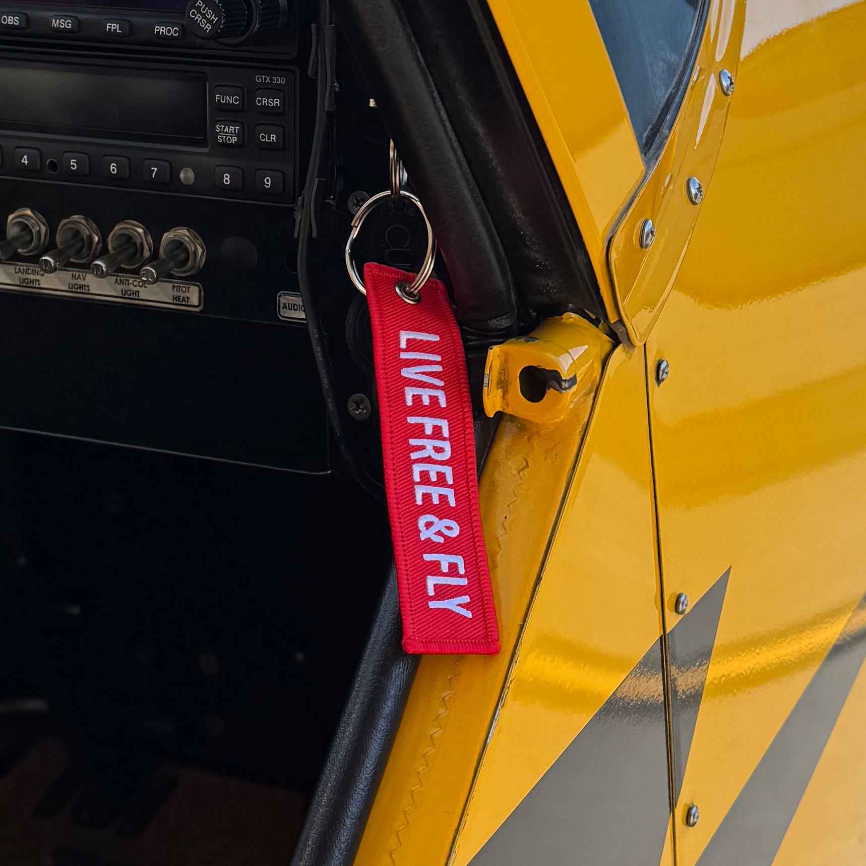 A red patch keychain attached to the key of an Super Cub airplane